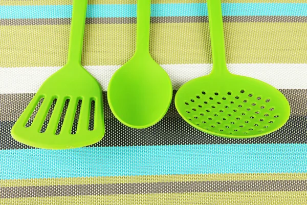 Utensili da cucina in plastica su sfondo tessuto — Foto Stock