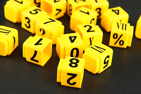 Educational cubes with different numbers on black board — Stock Photo, Image