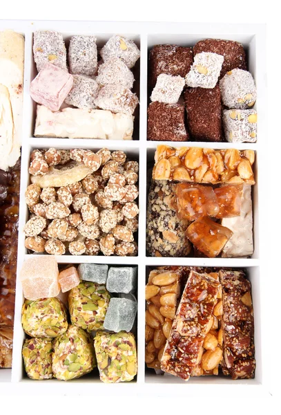 Sabrosos dulces orientales en caja de madera, aislados en blanco — Foto de Stock