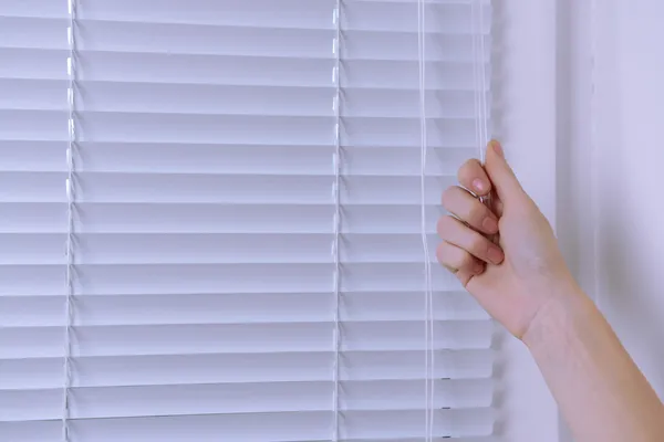 Hand öffnendes Fenster mit weißer Jalousie, Nahaufnahme — Stockfoto