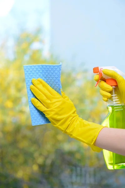 Manos con spray limpiando la ventana — Foto de Stock