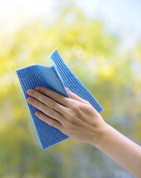 Hands with napkin cleaning window — Stock Photo, Image