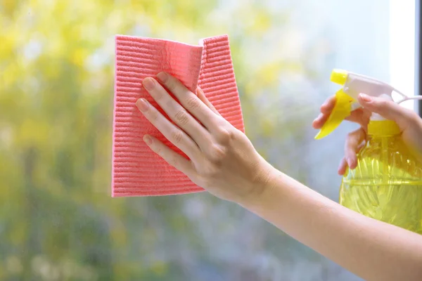 Hände mit Spray beim Fensterputzen — Stockfoto