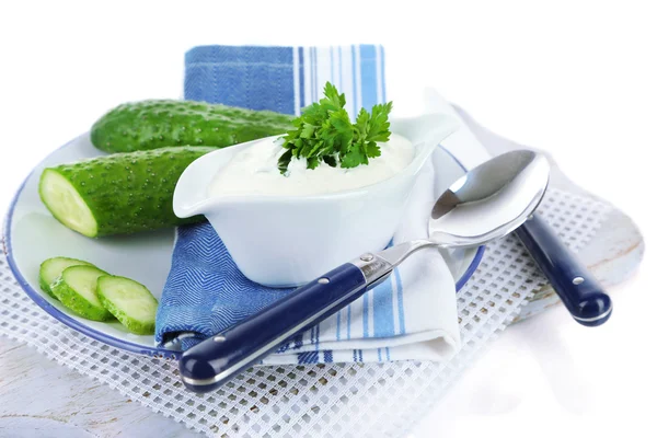 Cucumber yogurt in sauceboat, on color napkin, isolated on white — Stock Photo, Image