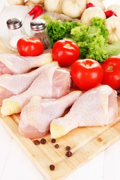 Raw chicken legs on wooden board close up — Stock Photo, Image
