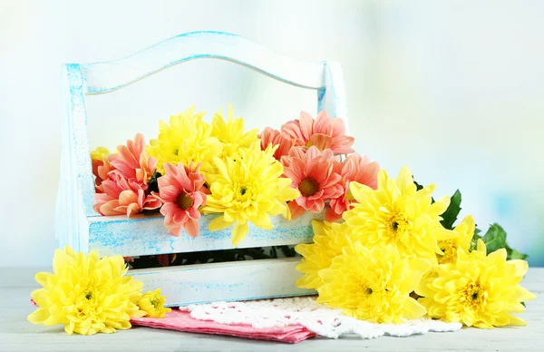 Beautiful flowers in basket, on light background — Stock Photo, Image