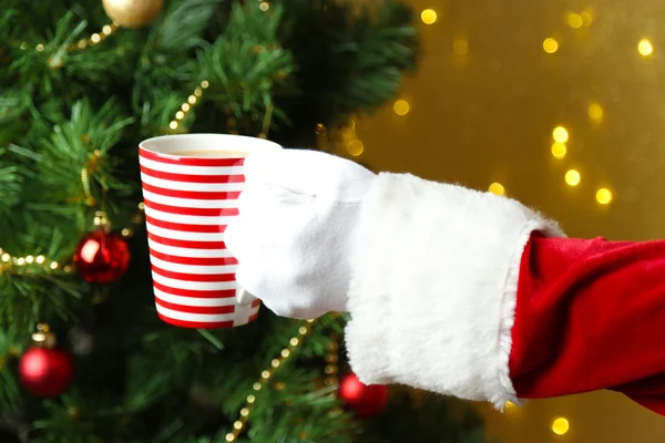 Taza de Santa sosteniendo en su mano, sobre fondo brillante —  Fotos de Stock