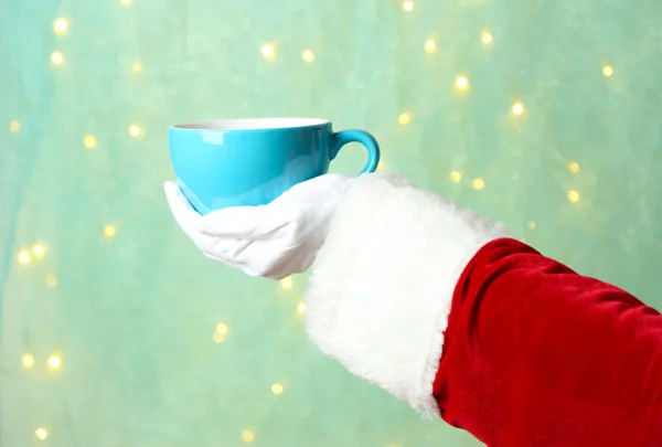 Santa holding mug in his hand, on light background — Stock Photo, Image