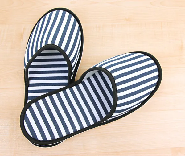 Gestreepte slippers op houten achtergrond — Stockfoto