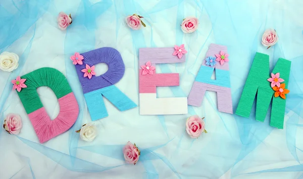 Word Dream created with brightly colored knitting yard on fabric background — Stock Photo, Image