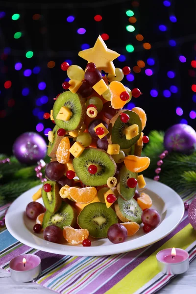 Árbol de Navidad de frutas en la mesa sobre fondo oscuro —  Fotos de Stock