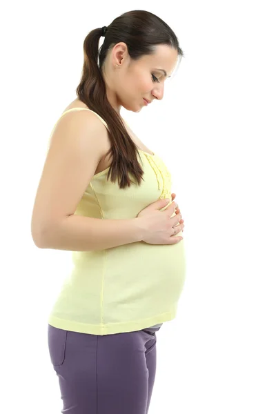 Mooie jonge zwangere vrouw aan haar buik op wit wordt geïsoleerd te raken — Stockfoto