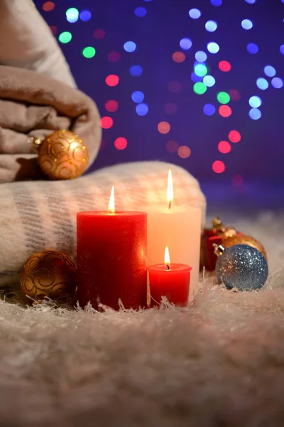 Sammansättning med plädar, ljus och juldekorationer, på vita mattan på ljus bakgrund — Stockfoto