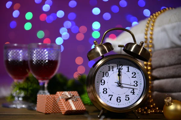 Wine glasses, retro alarm clock and Christmas decoration on bright background — Stock Photo, Image