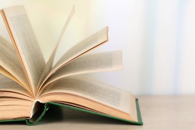 parlak zemin üzerine ahşap masa kitap açıldı