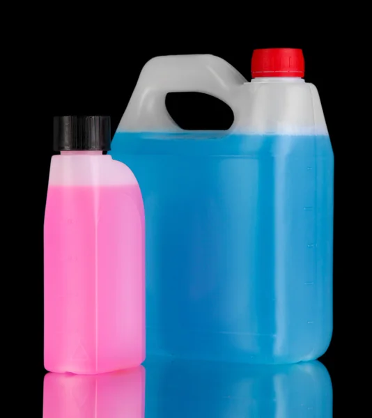 Blue and pink liquids for car in canisters on black background — Stock Photo, Image