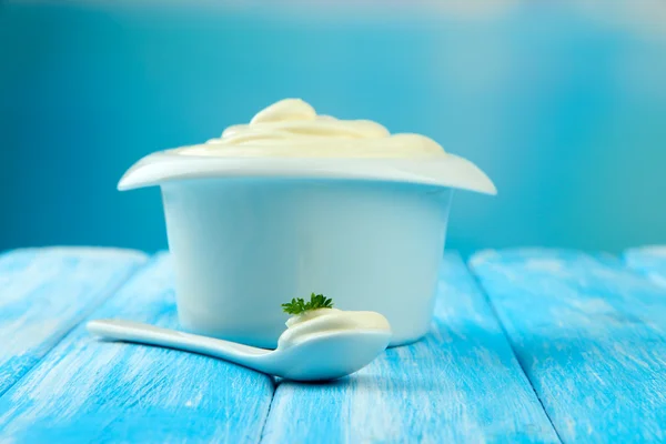 Sour cream in bowl on table on bright background — Stock Photo, Image