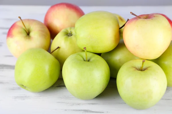 Šťavnatá jablka na dřevěný stůl — Stock fotografie