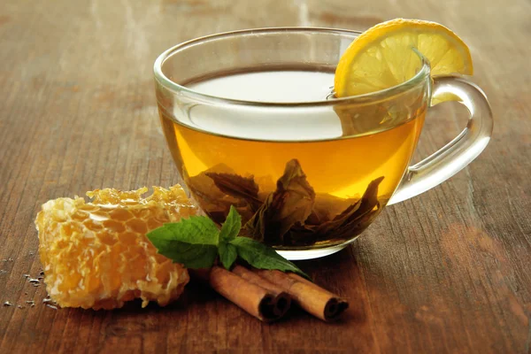 Průhledný šálek zeleného čaje s medem a skořicí na dřevěném pozadí — Stock fotografie