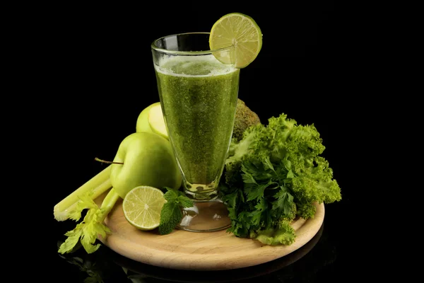 Glass of green vegetable juice and vegetables isolated on black — Stock Photo, Image