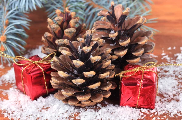 Kerstversiering met dennenappels op houten achtergrond — Stockfoto