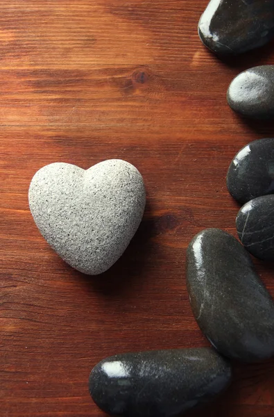 Серый камень в форме сердца, на деревянном фоне — стоковое фото