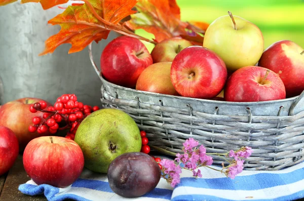 Saftige Äpfel im Korb auf dem Tisch vor natürlichem Hintergrund — Stockfoto