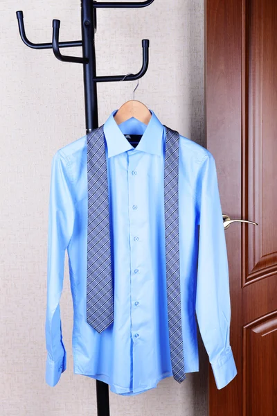 Shirt hanging on hanger near door — Stock Photo, Image