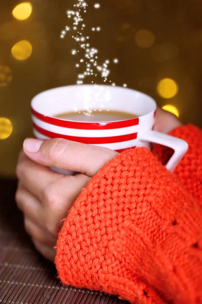 Hands holding mug of hot drink, close-up, on bright background — Stock Photo, Image