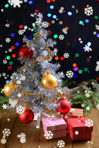 Árvore de Natal decorativa com presentes na mesa em fundo brilhante — Fotografia de Stock