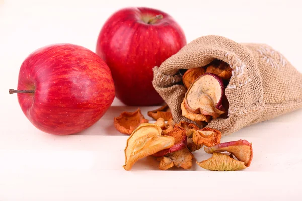 Getrocknete Äpfel und frische Äpfel, auf weißem Holzgrund — Stockfoto