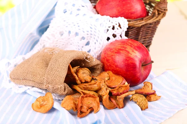 Manzanas secas y manzanas frescas, en servilleta, sobre fondo de madera blanca — Foto de Stock