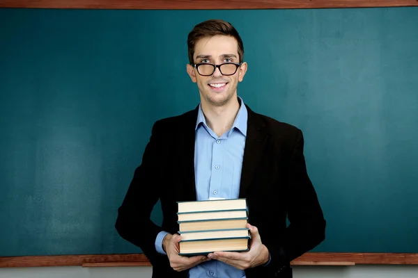 Jonge leraar in de buurt van schoolbord in school klas — Stockfoto