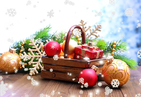 Composition with Christmas decorations in basket, fir tree on wooden table, on light background — Stock Photo, Image