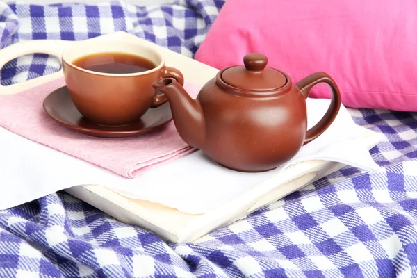 Taza y tetera en bandeja de madera sobre fondo de tela — Foto de Stock