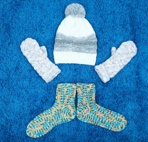 Winter cap, socks and gloves, on color background — Stock Photo, Image