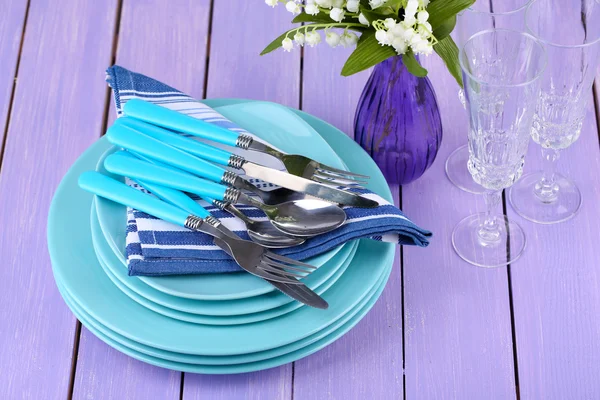 Clean dishes on wooden table on color background — Stock Photo, Image