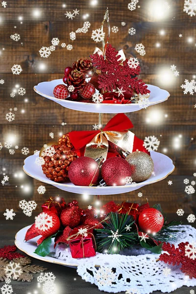 Christmas decorations on dessert stand, on wooden background — Stock Photo, Image