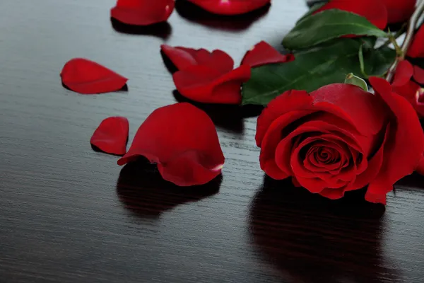 Krásné červené růže na dřevěný stůl detail — Stock fotografie