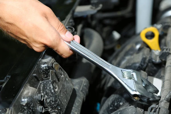 Mano con llave inglesa. Mecánico de automóviles en la reparación de automóviles — Foto de Stock