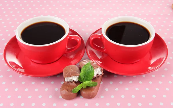 Rode kopjes sterke koffie en chocolade bars op polka dot achtergrond — Stockfoto