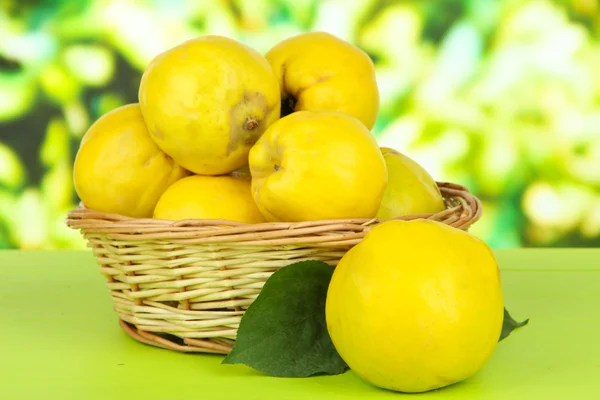 Sweet quinces in wicker basket on table on bright background — Stock Photo, Image