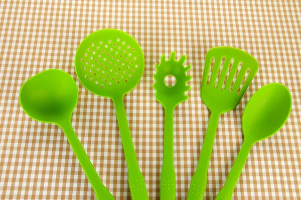 Plastic kitchen utensils on fabric background — Stock Photo, Image