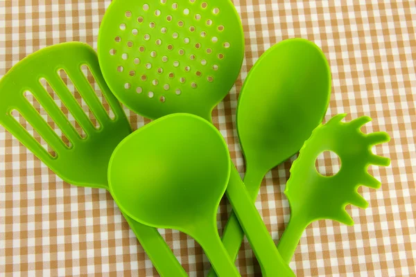 Utensili da cucina in plastica su sfondo tessuto — Foto Stock