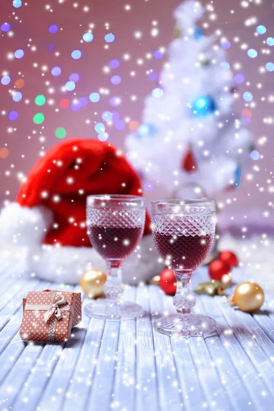Copos de vinho e decoração de Natal no fundo brilhante — Fotografia de Stock