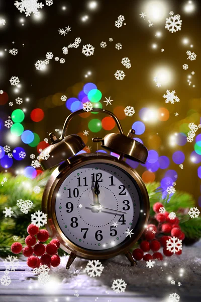 Christmas decorations and retro alarm clock on wooden table, on bright background — Stock Photo, Image