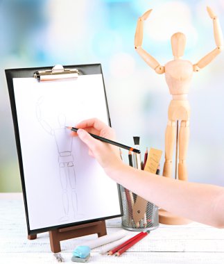 Hand draws a sketch with professional art materials, on wooden table clipart