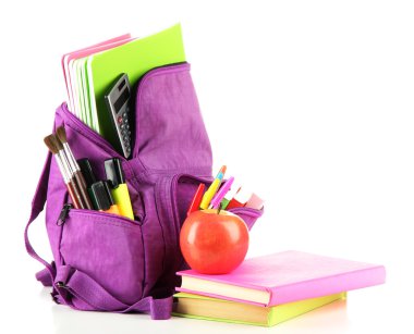 Okul malzemelerinin bulunduğu mor sırt çantası beyazın üzerinde.