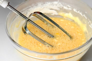 Yemek, yumurta bir kapta elektrikli çırpma teli ile kırbaçlanan, yakın çekim