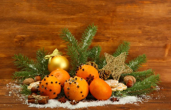 Christmas composition with oranges and fir tree, on wooden background — Stock Photo, Image